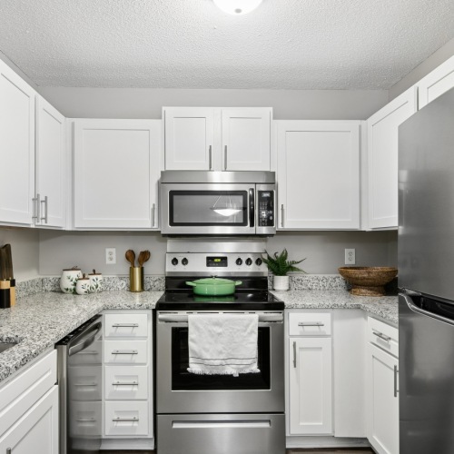 Apartment kitchen with modern appliances and white cabinets at Fieldstone Apartment Homes in Mebane, NC
